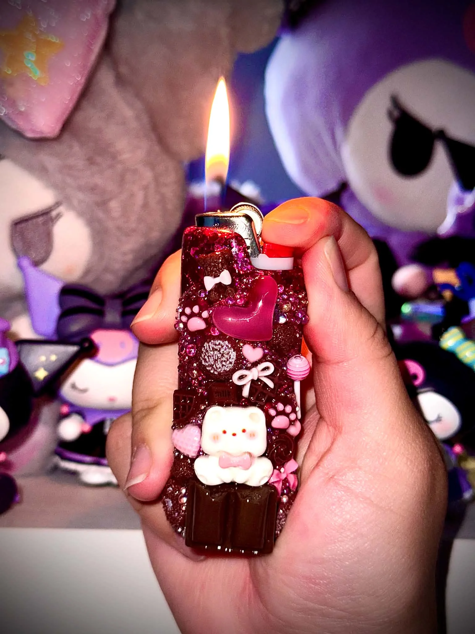 Deep pink charm-covered lighter case held in a hand